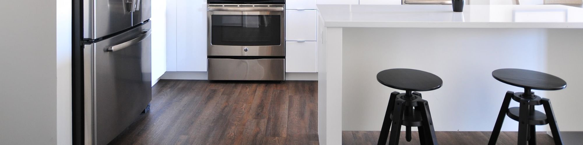 Durable hardwood flooring in a modern white kitchen